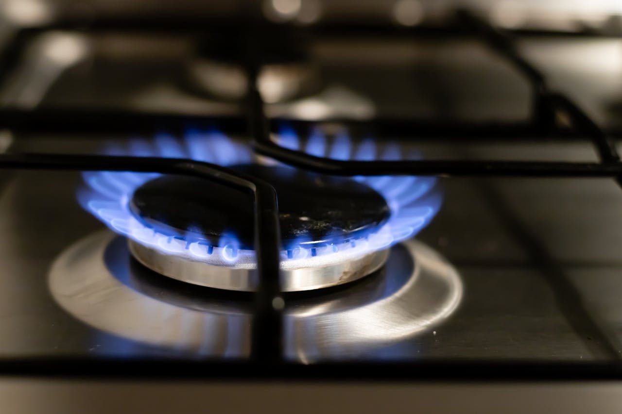 A detailed view of a blue flame on a stove, showcasing energy and heat.